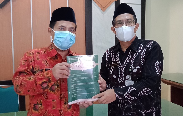 Kepala Kankemenag Kab. Cilacap menerima jurnal Pakerti dari ketua DPD PGMI Kabupaten Cilacap