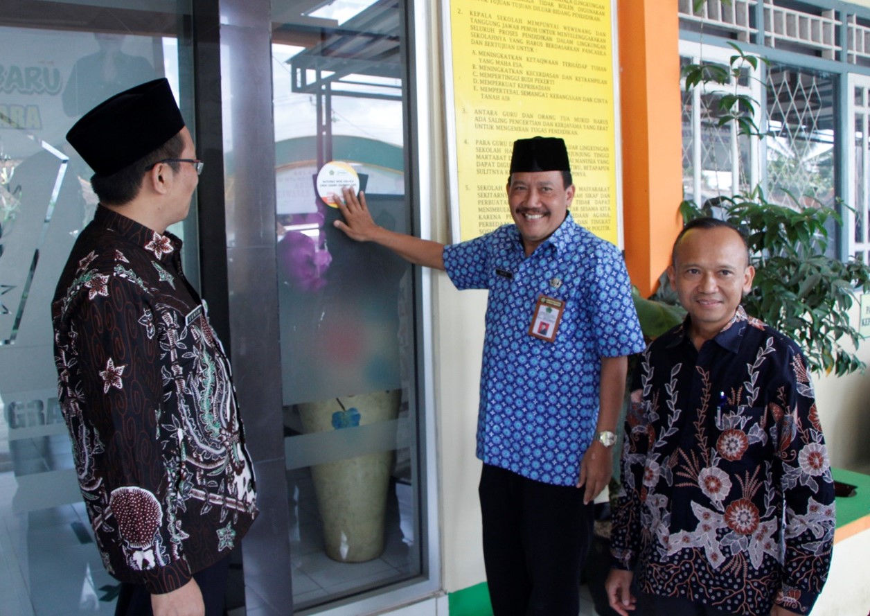 Disaksikan Kasubbag TU, Kepala MTsN 3 Banjarnegara Tempel Stiker Zona Integritas WBK dan WBBM